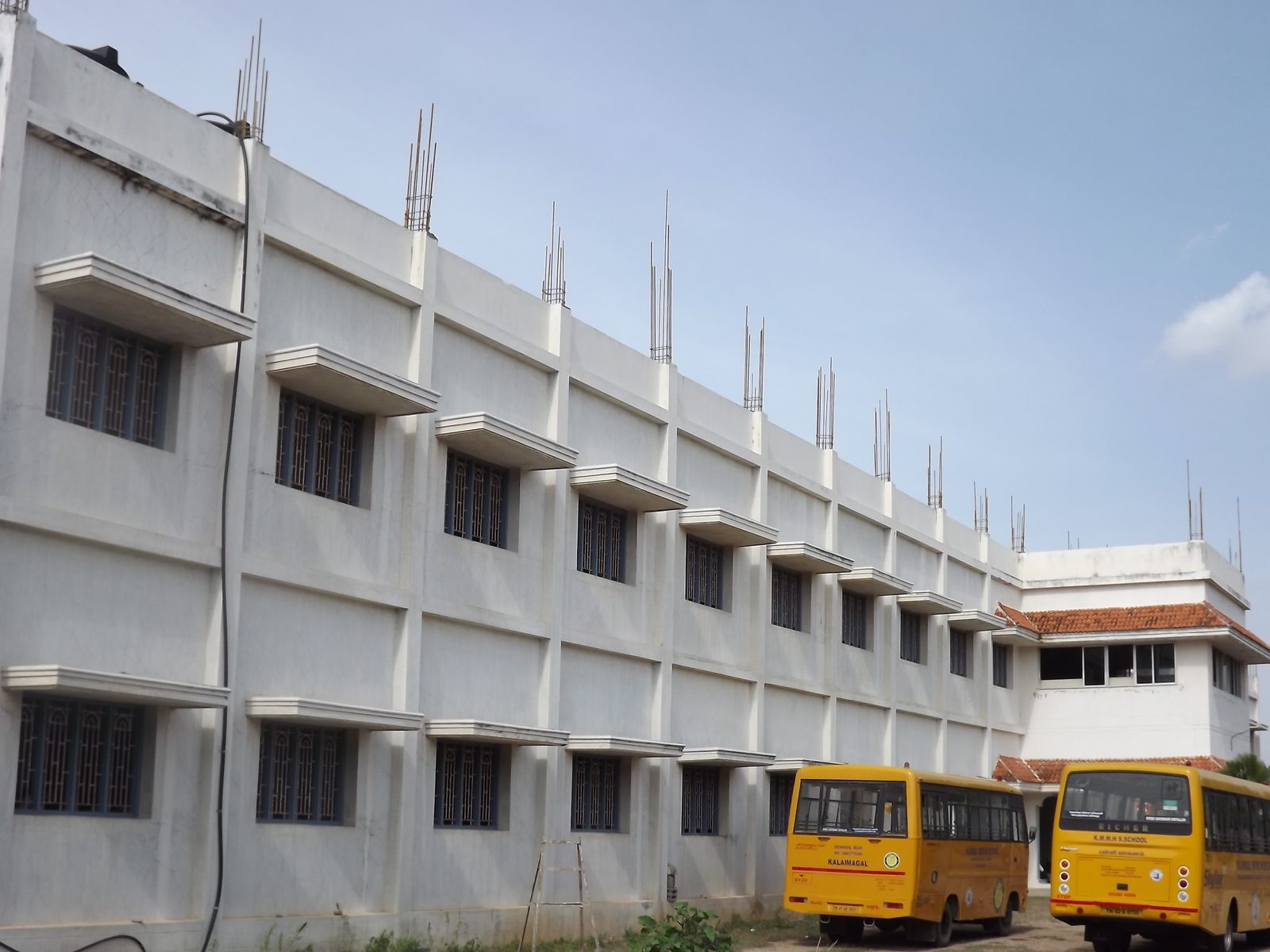 School block with buses parked outside