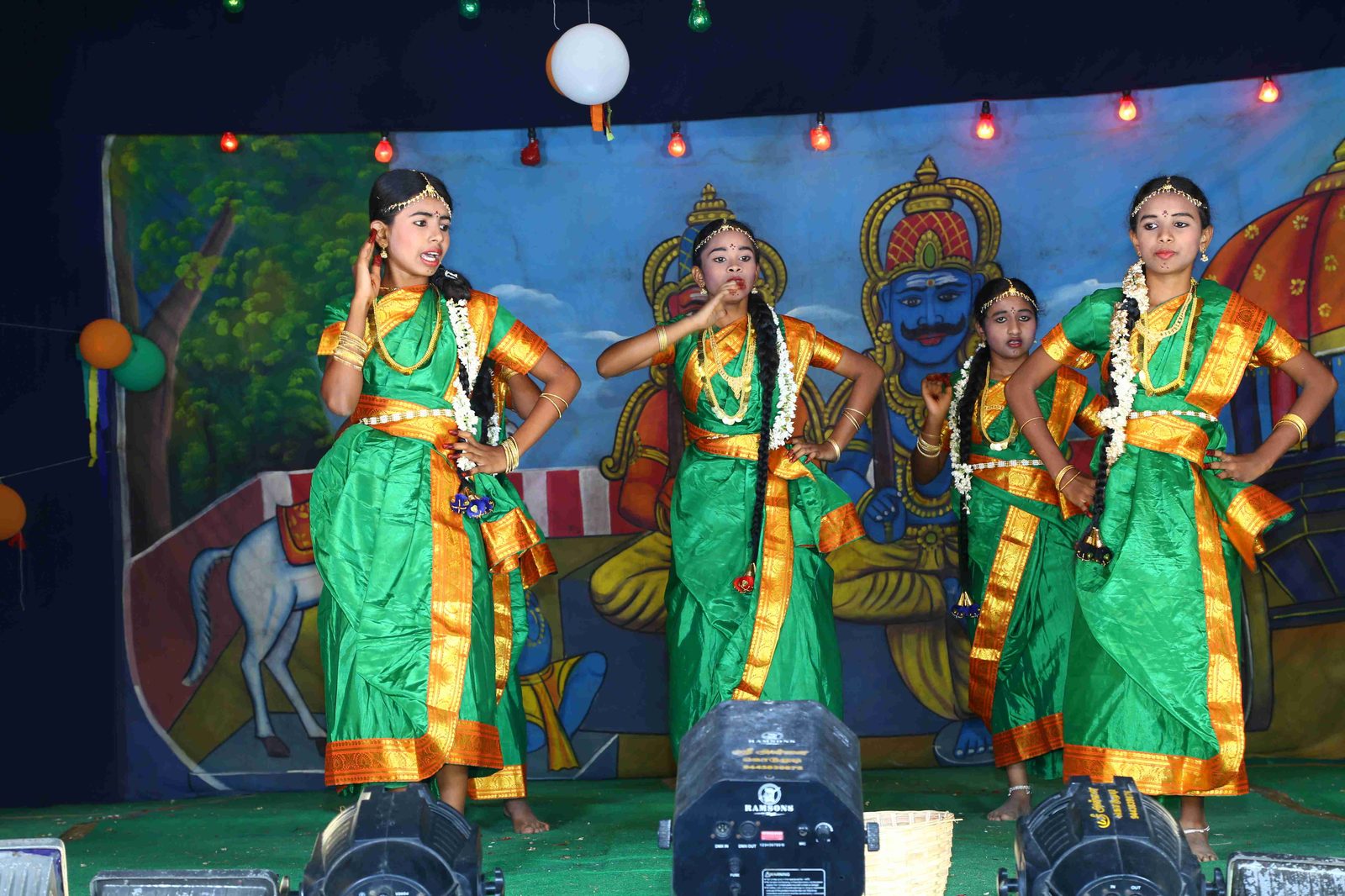 Students performing a classical dance on stage